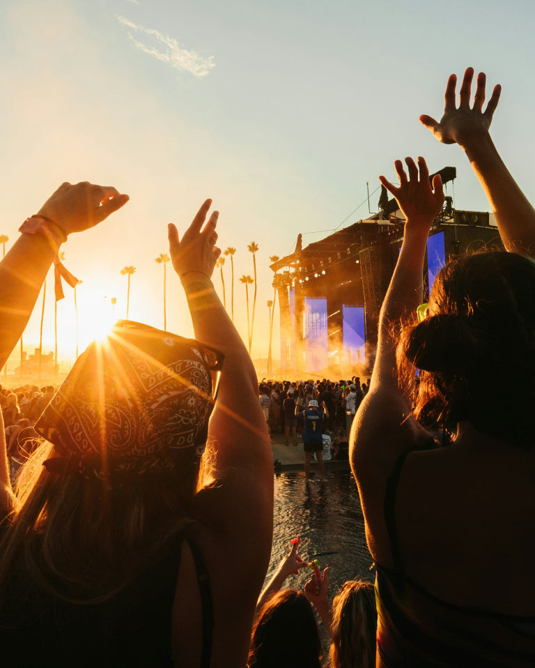 a group of people raising their hands in the air at a festival