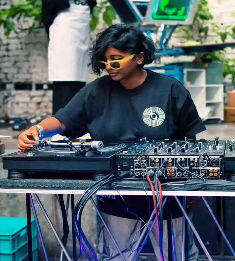 DJ mixing music on turntable and audio mixer at an outdoor event