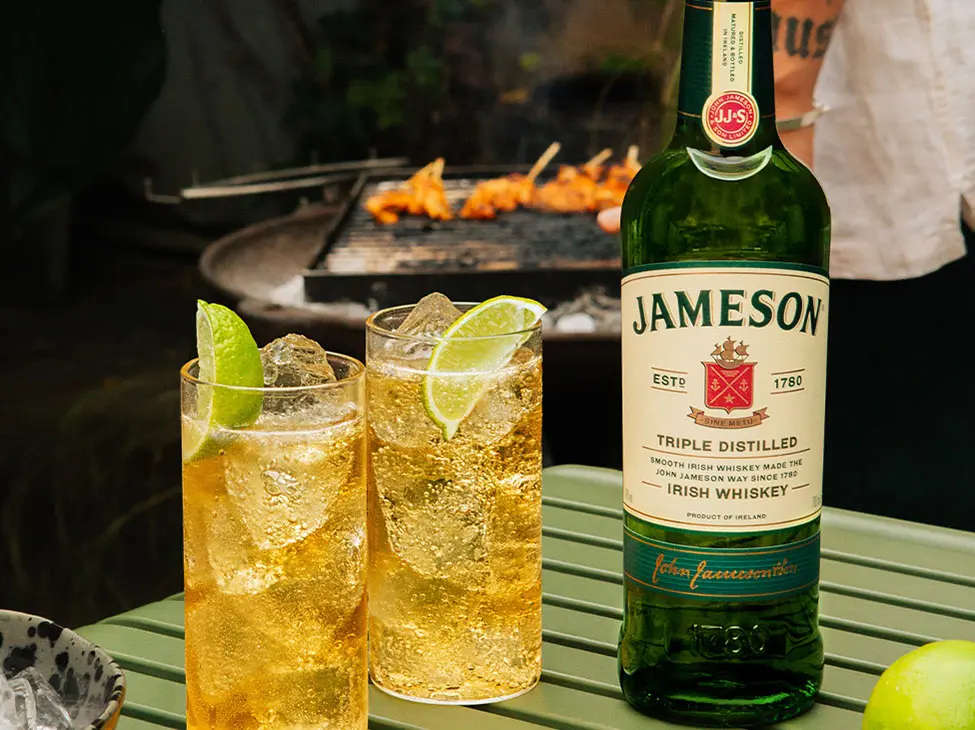 2 glasses of Jameson, ginger & lime whiskey cocktail with Jameson Original bottle