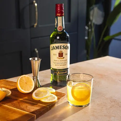 a bottle and two glasses of jameson original sitting on a table