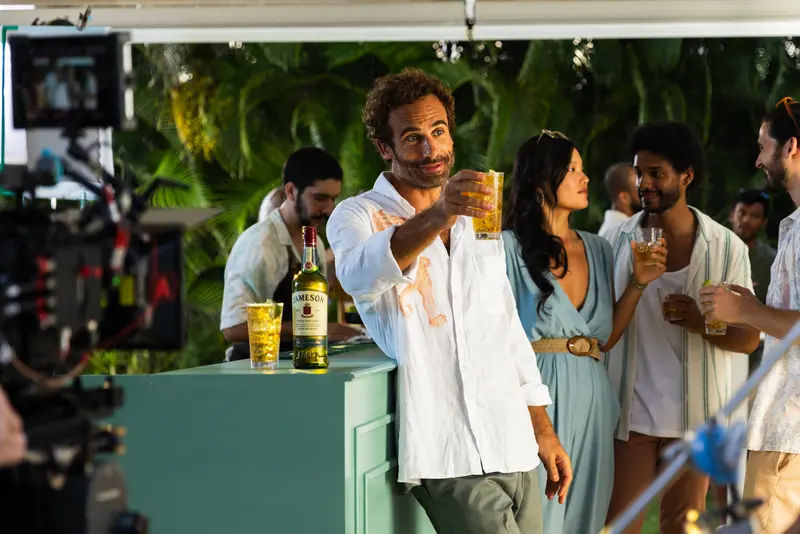 A man doing a toast with a Jameson, ginger and lime cocktail