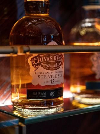 Warmly lit close-up of a Strathisla whisky bottle.