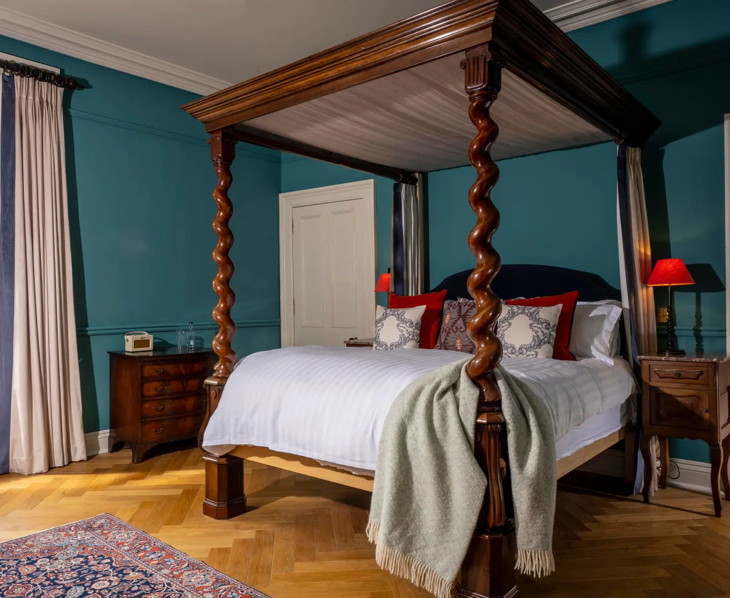 Stylish Strathisla bedroom with a four-poster bed, teal walls and large window for natural light.