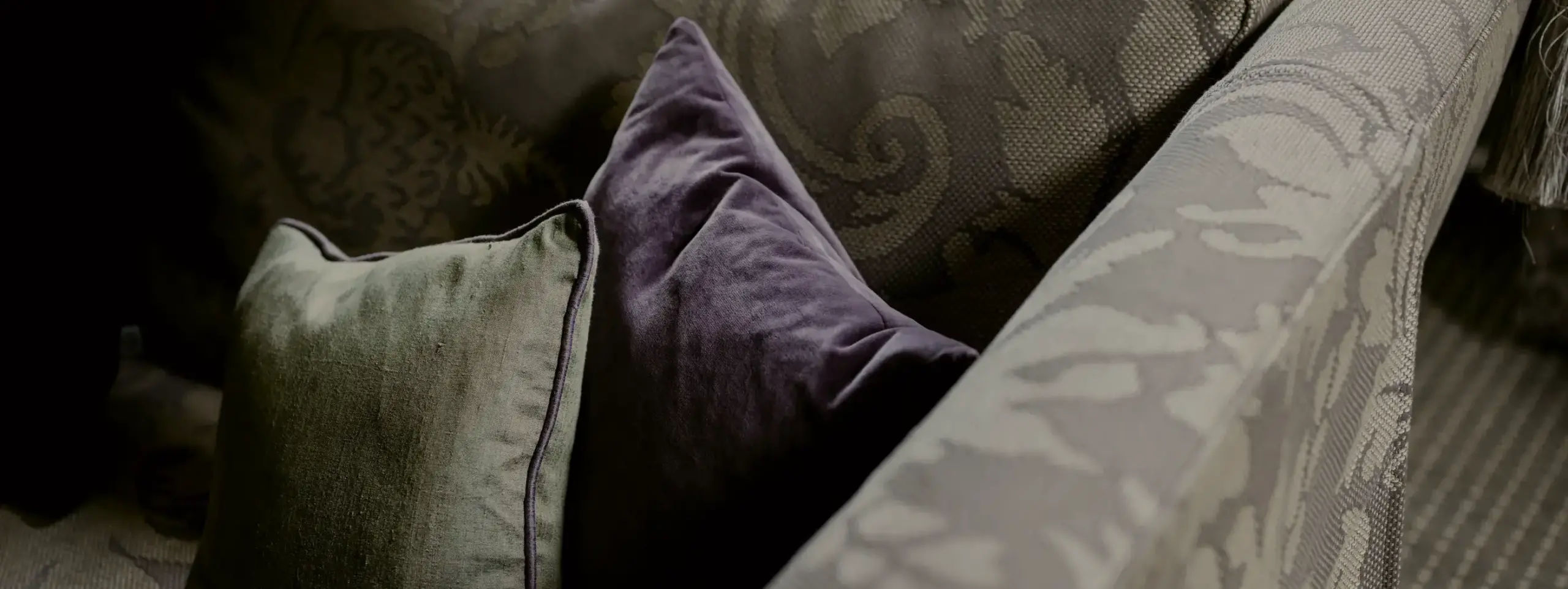Close-up of elegant cushions with intricate patterns, arranged on a plush sofa in Linn House.