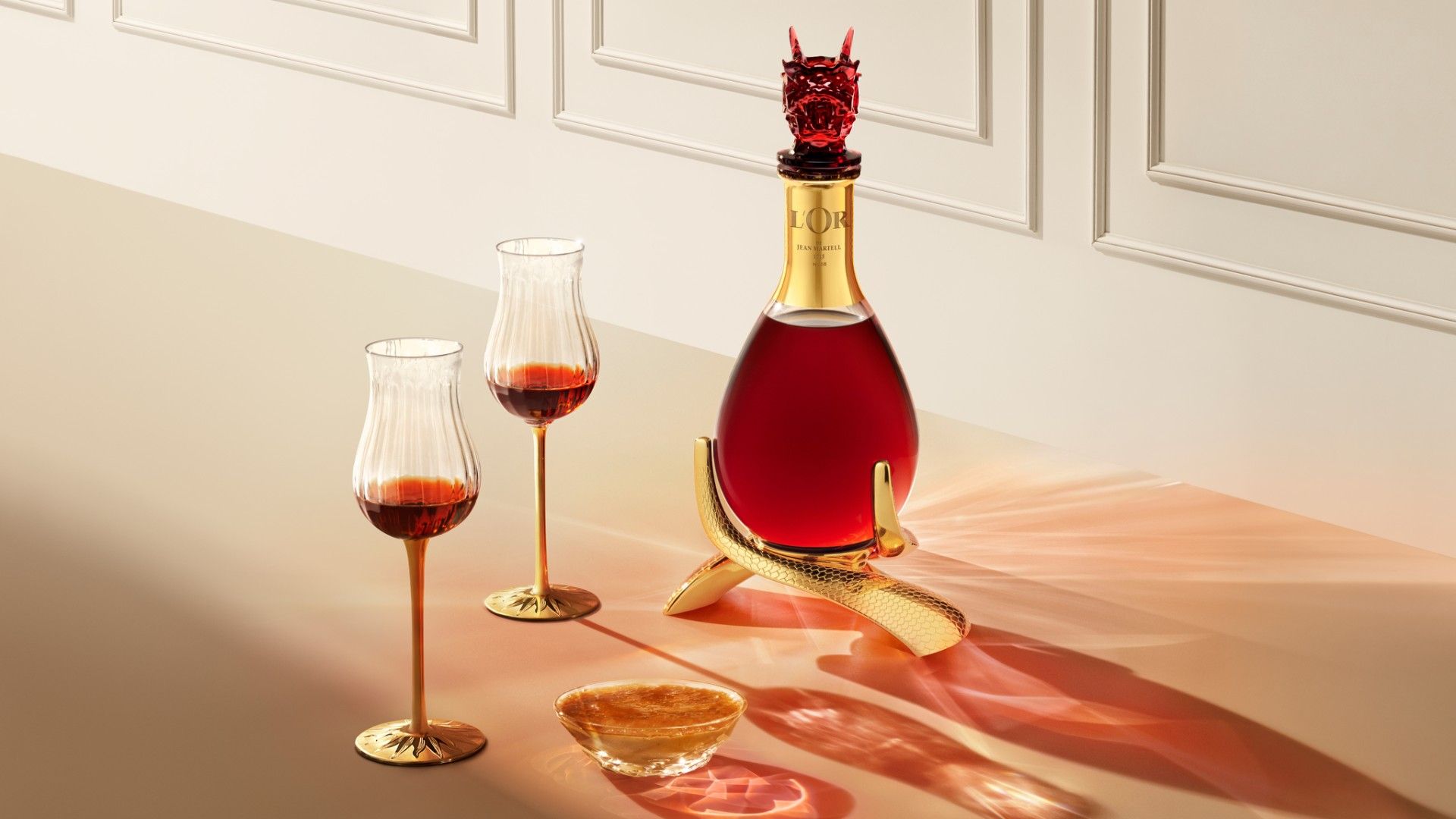 Visual of the bottle L'Or de Jean Martell - Zodiac Edition L'Assemblage du Dragon with two glasses on a table