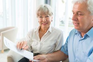 Elderly couple signing papers