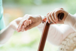 caregiver helping elderly patient stand