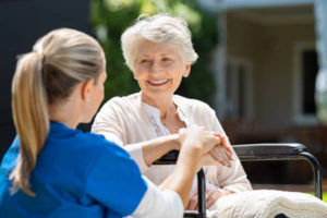 elderly woman smiling at her in home caregiver