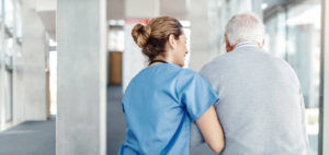 eldery man walking with home care nurse