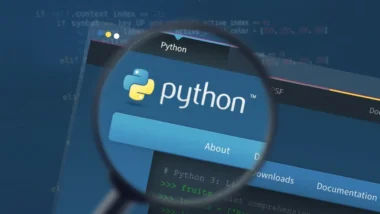 Interfaz de código Python en una laptop con el curso de Udemy de fondo