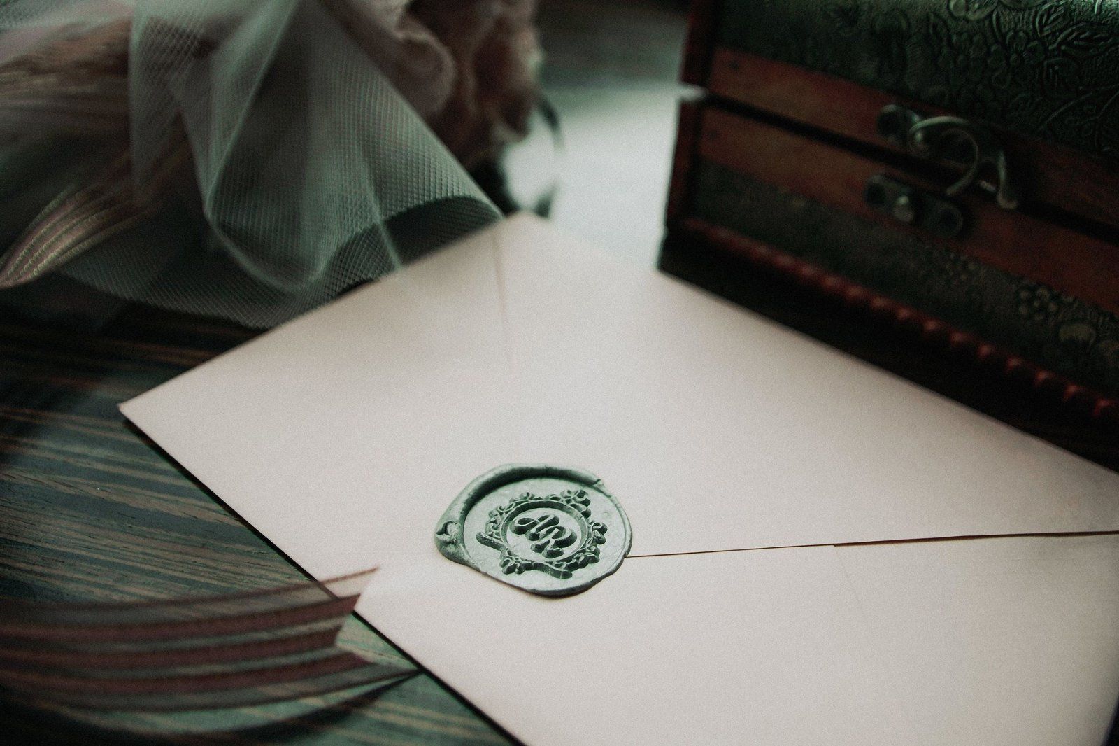 Back flap of a wedding invitation envelope closed with a wax seal, where the return address traditionally sits