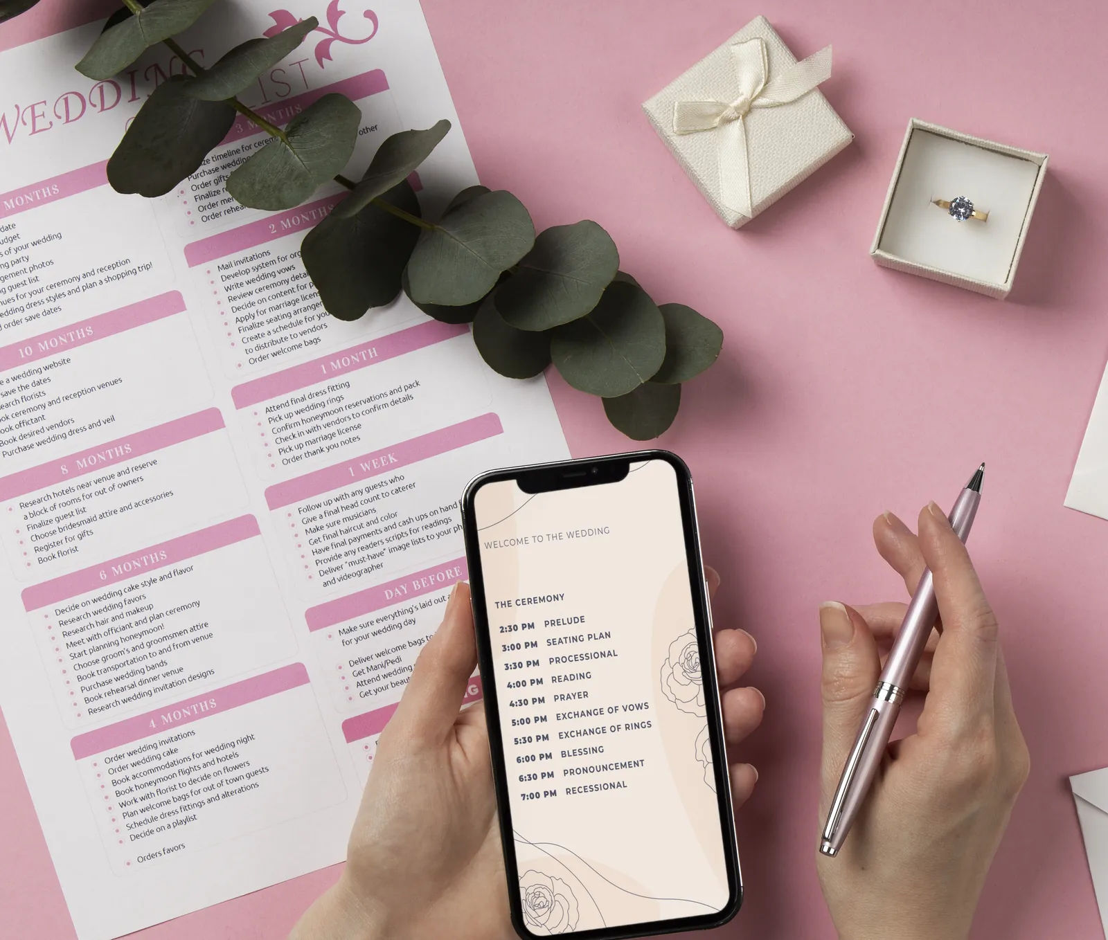 Wedding planning checklist and engagement ring on a desk while a couple works through their guest list