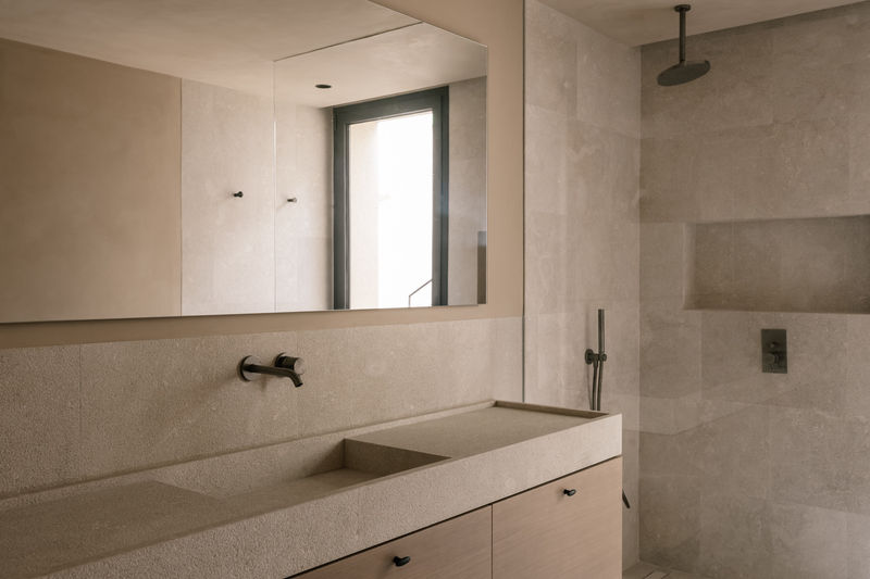 Bathroom with stone washbasin and brushed black fixtures
