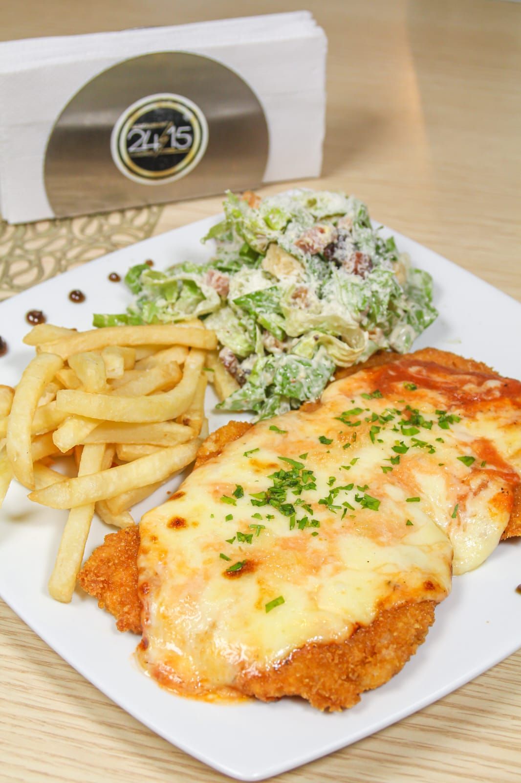 Milanesa de pollo a la parmesana con César y papas fritas