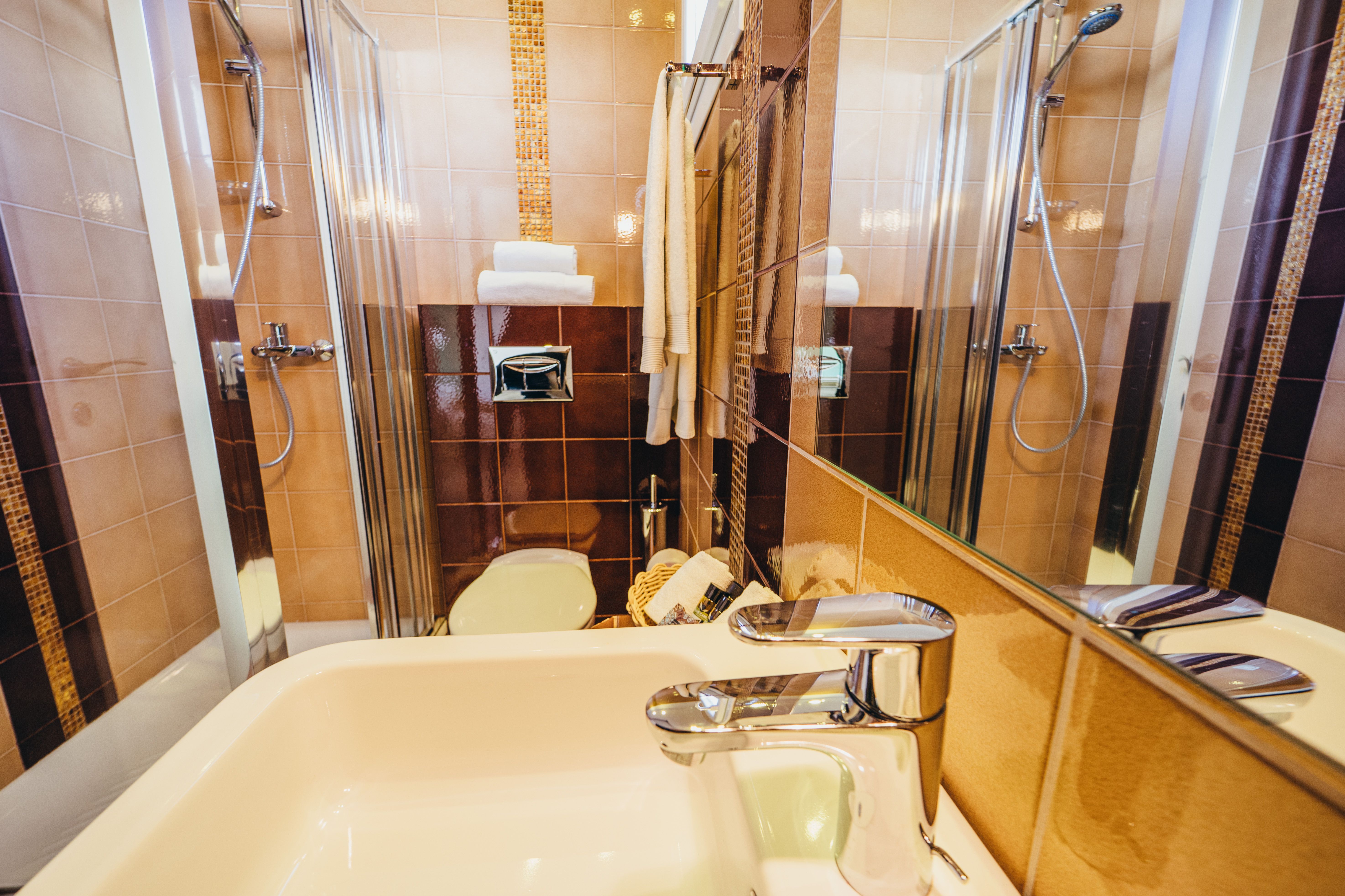 Private bathroom with sink and mirror in deluxe green room