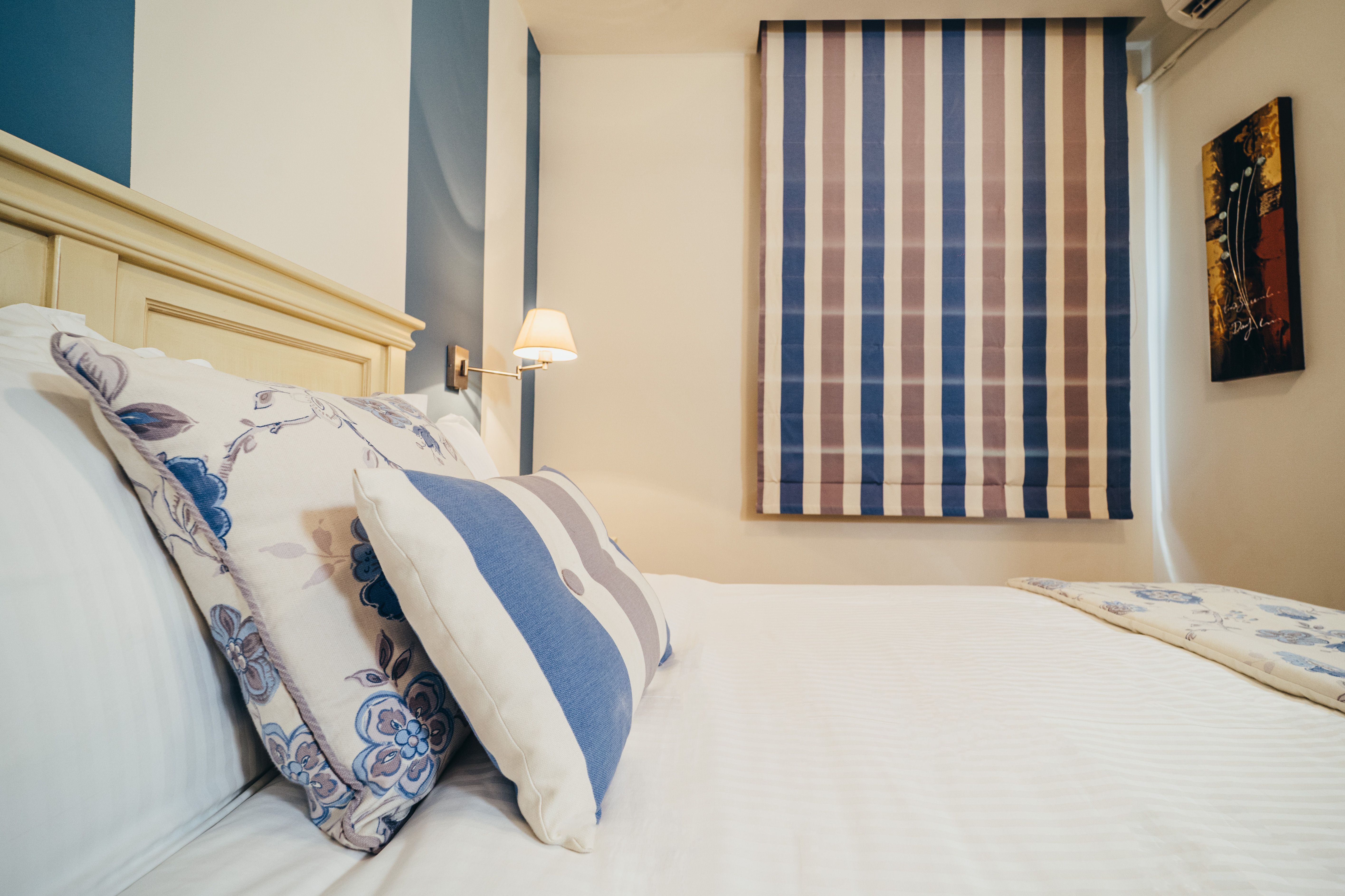 Budget room interior with double bed and window curtains