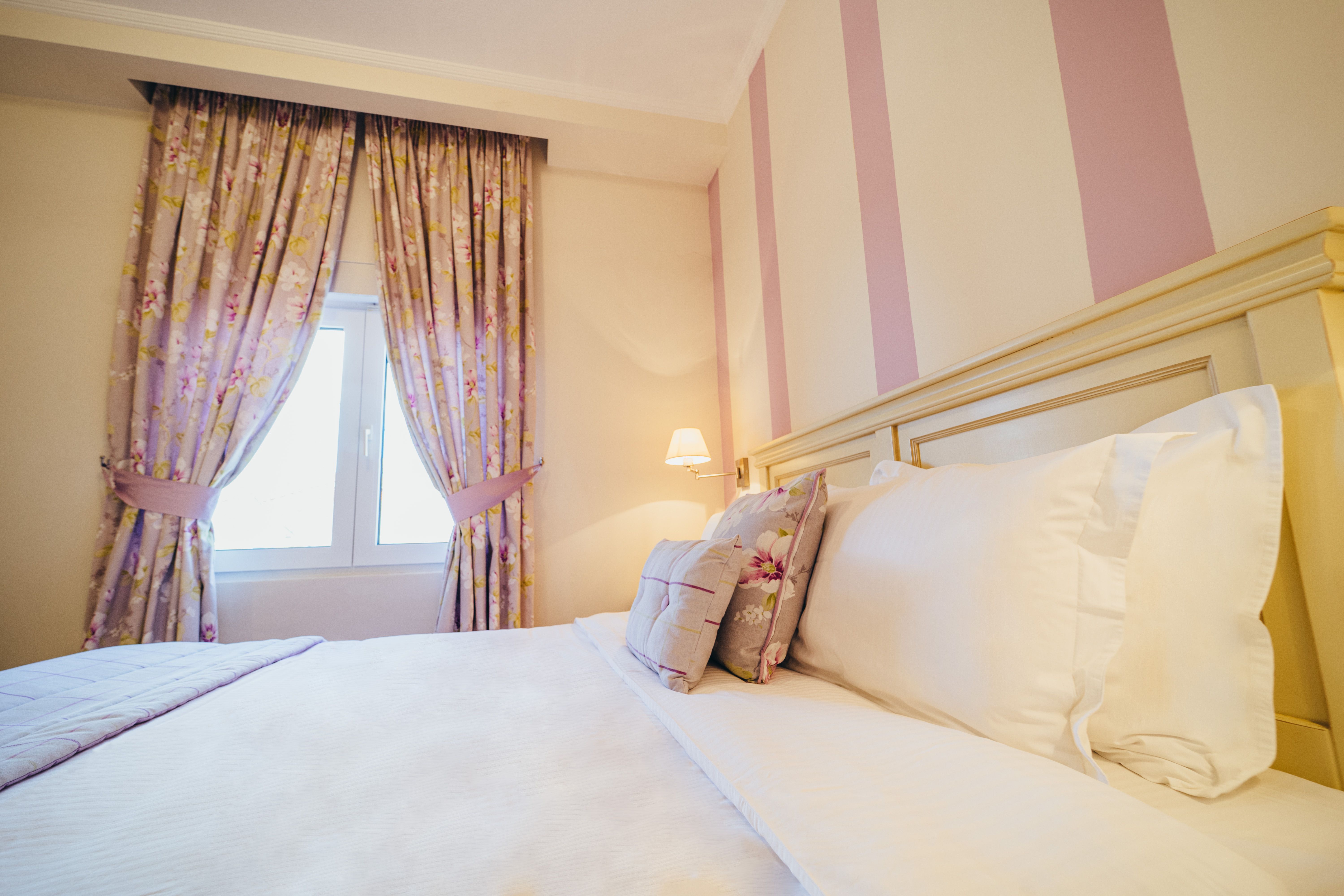 Double bed with pillows in deluxe purple room