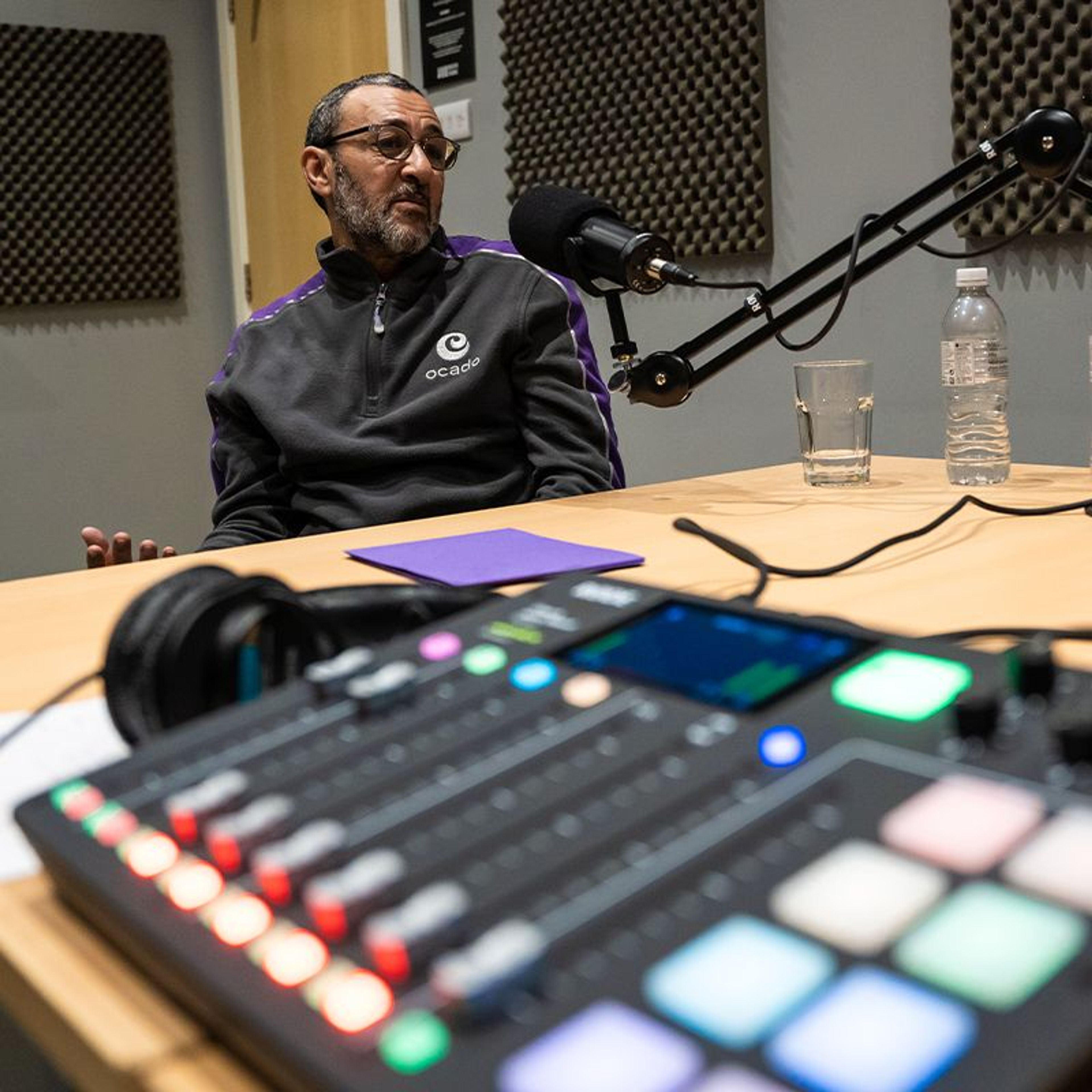 An Ocado employee sat at a desk in a podcast studio