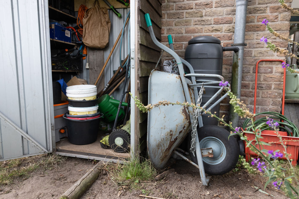 Vrijwilliger uitleen tuingereedschap en zaden bij de Plataan op maandagmiddag
