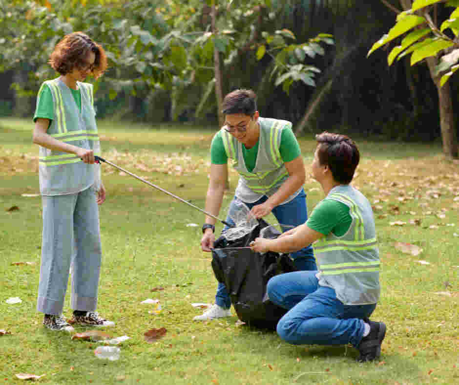 three people in high vis jackets picking up litter