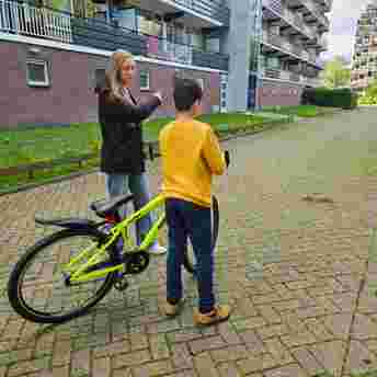 Leerling maatschappelijke diensttijd zet zich in als steunjongere en leert een jongetje fietsen Leerling maatschappelijke diensttijd zet zich in als steunjongere en leert een jongetje fietsen