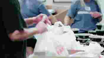 Volunteers helping to pack supplies in bag