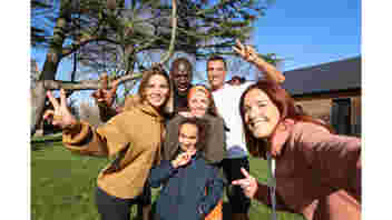 A Group of six friends gathered into a close group to take a selfie
