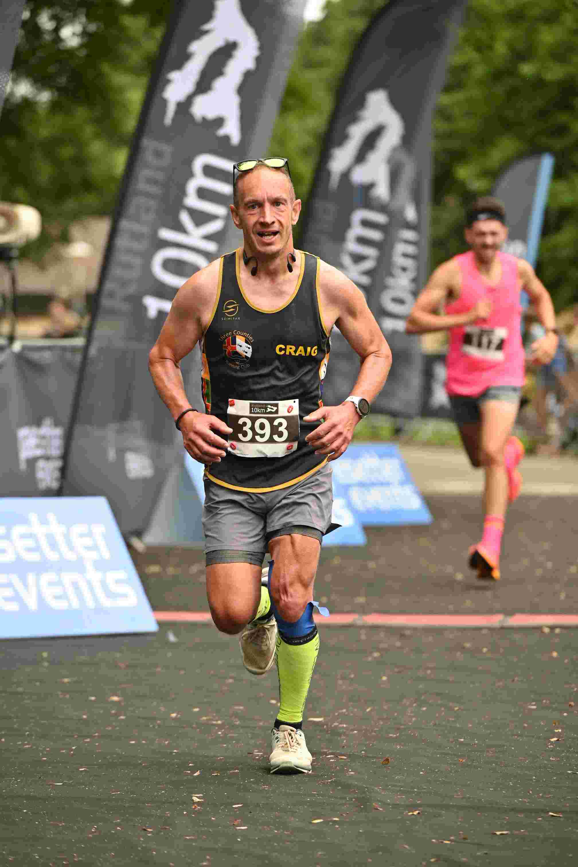 Craig taking part in a fundraising 10K race. He is wearing running gear and is smiling.