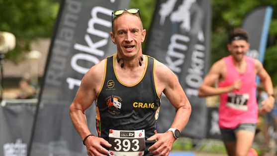 Craig taking part in a fundraising 10K race. He is wearing running gear and is smiling.