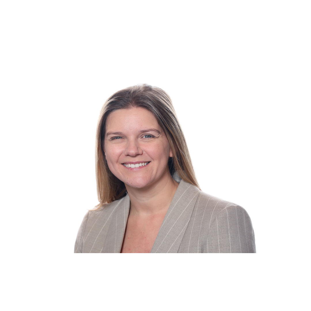 Natalie smiles to camera, she has shoulder length brown hair and is wearing a grey suit.