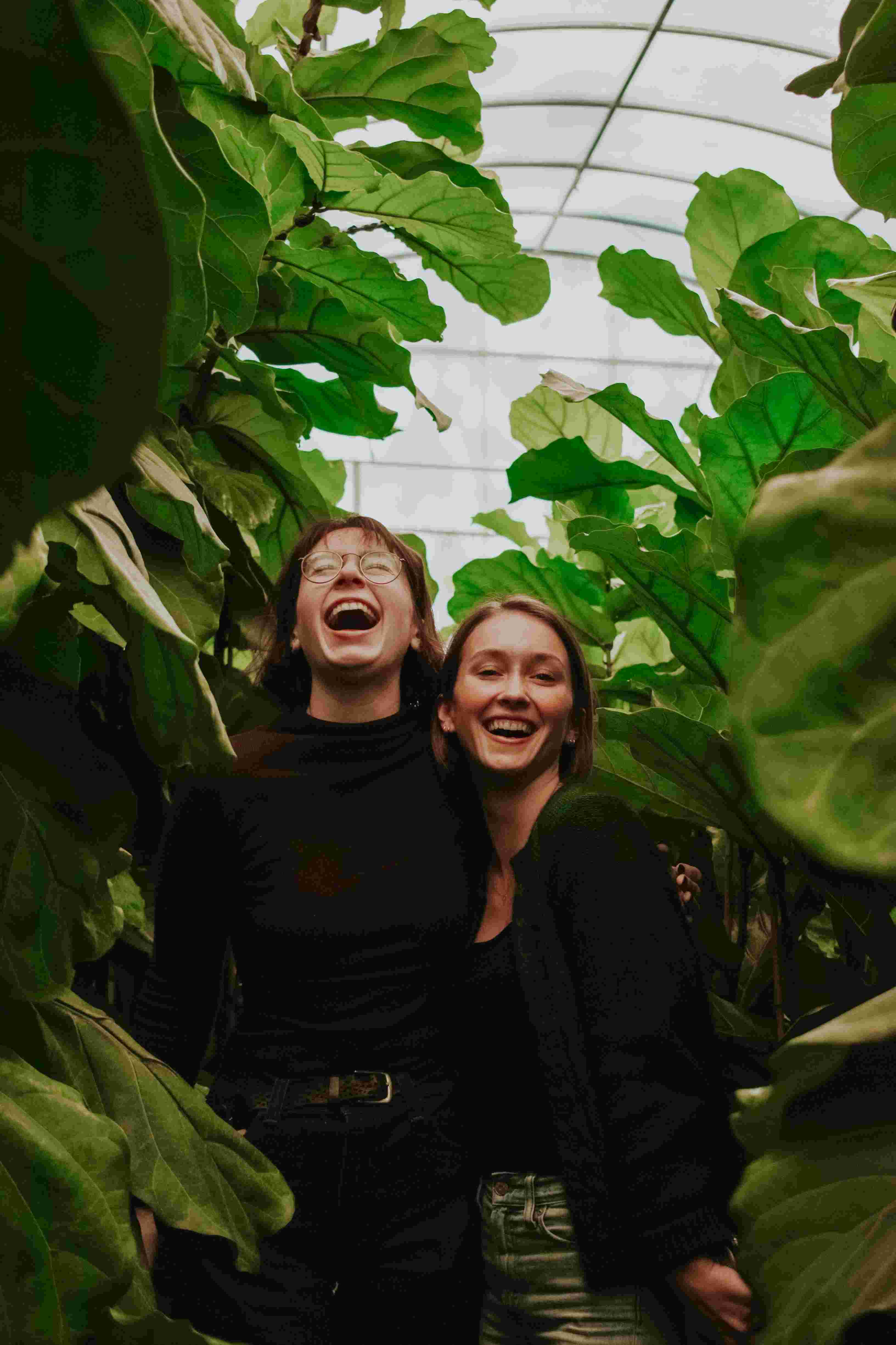 Twee lachende jonge mensen tussen de planten