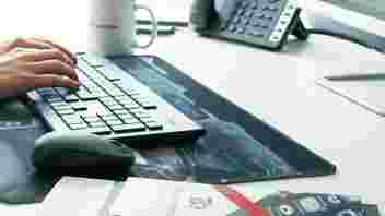 close-up of hands on a keyboard on a desk