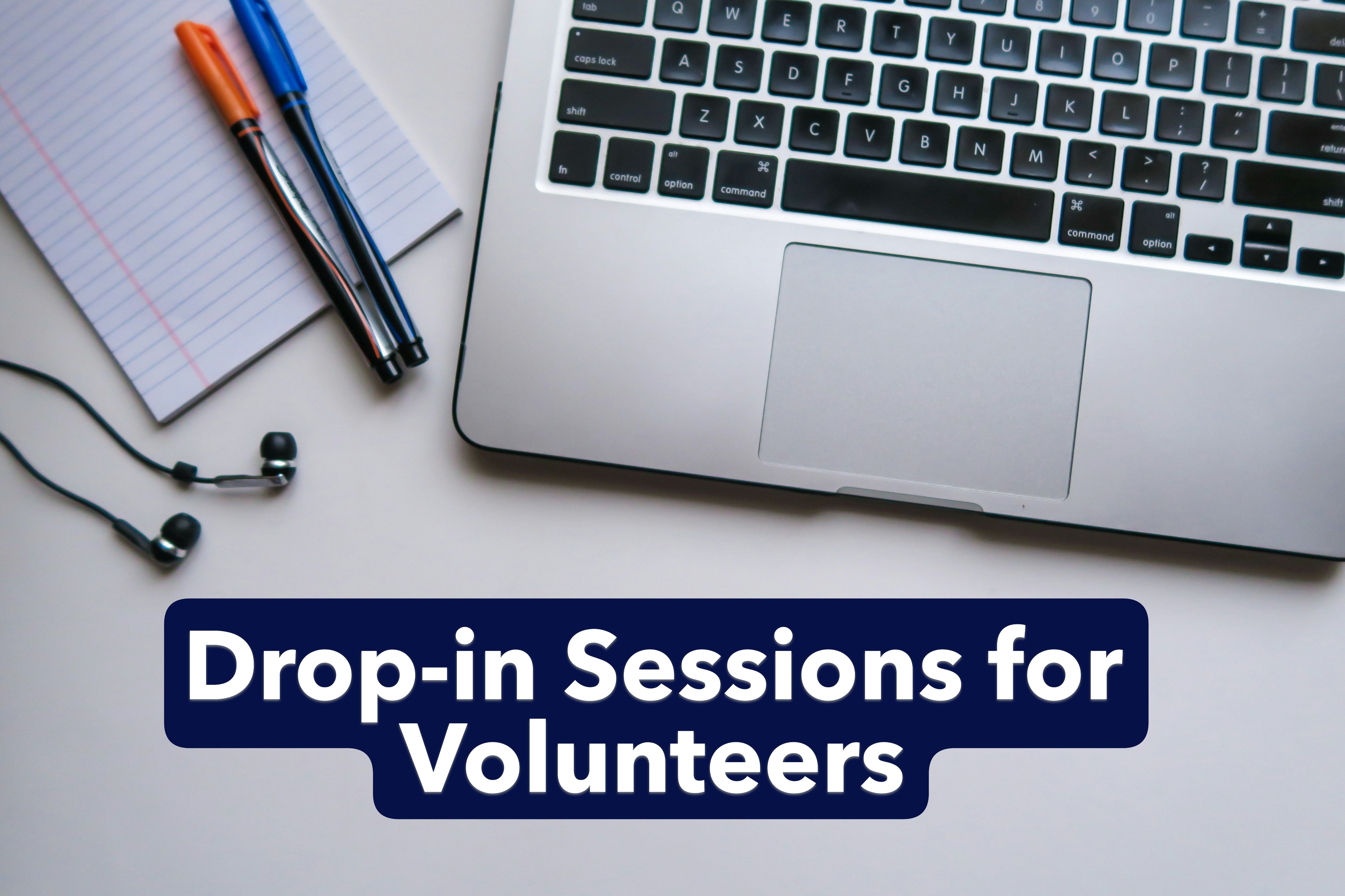 Laptop, paper, and pens with 'Drop-in Sessions for Volunteers' written below