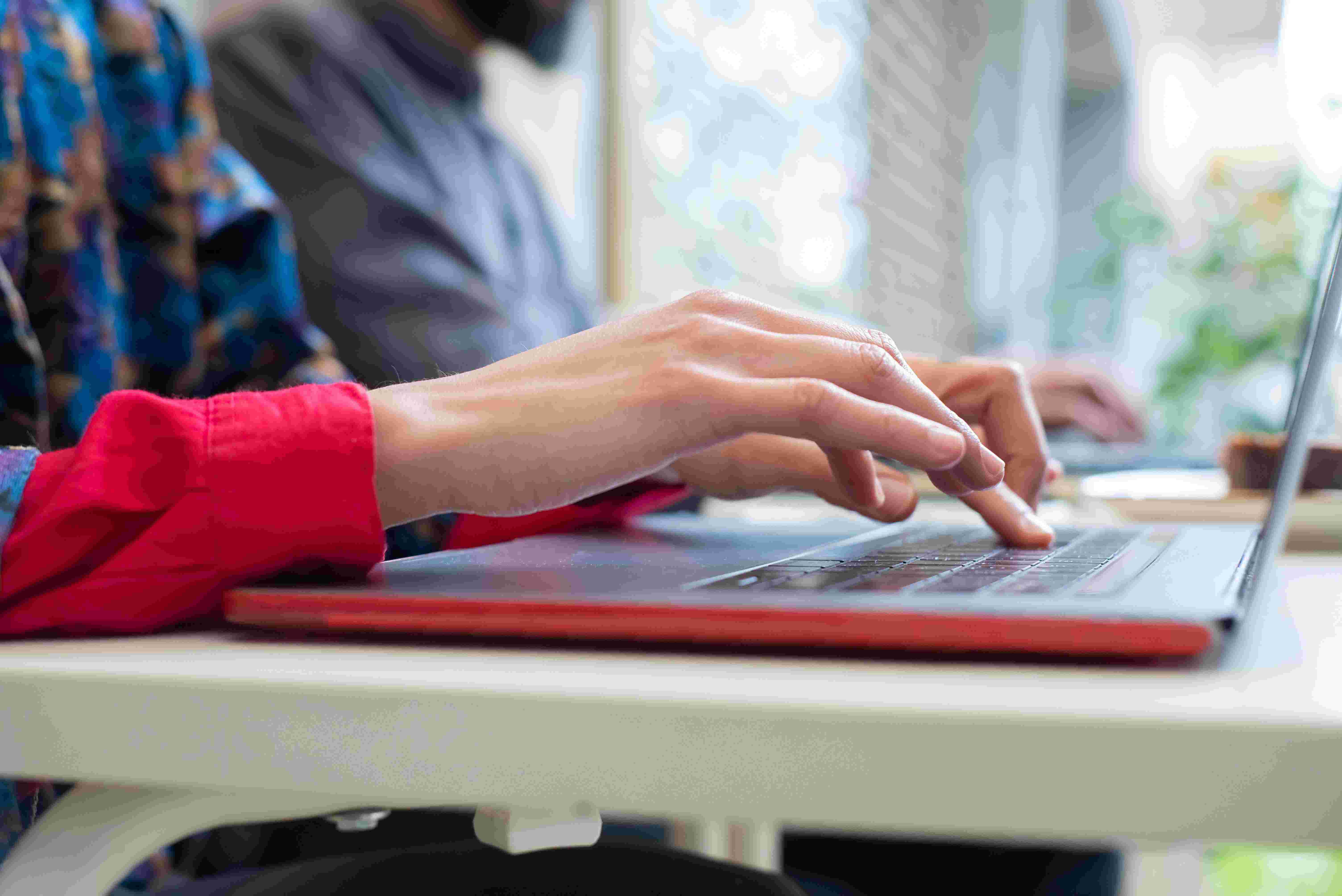 Handen op een laptop-toetsenbord