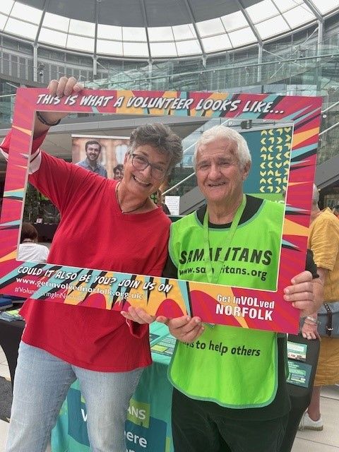 Two volunteers from the Samaritans with their faces inside a giant frame that says "This is what a volunteer looks like..."