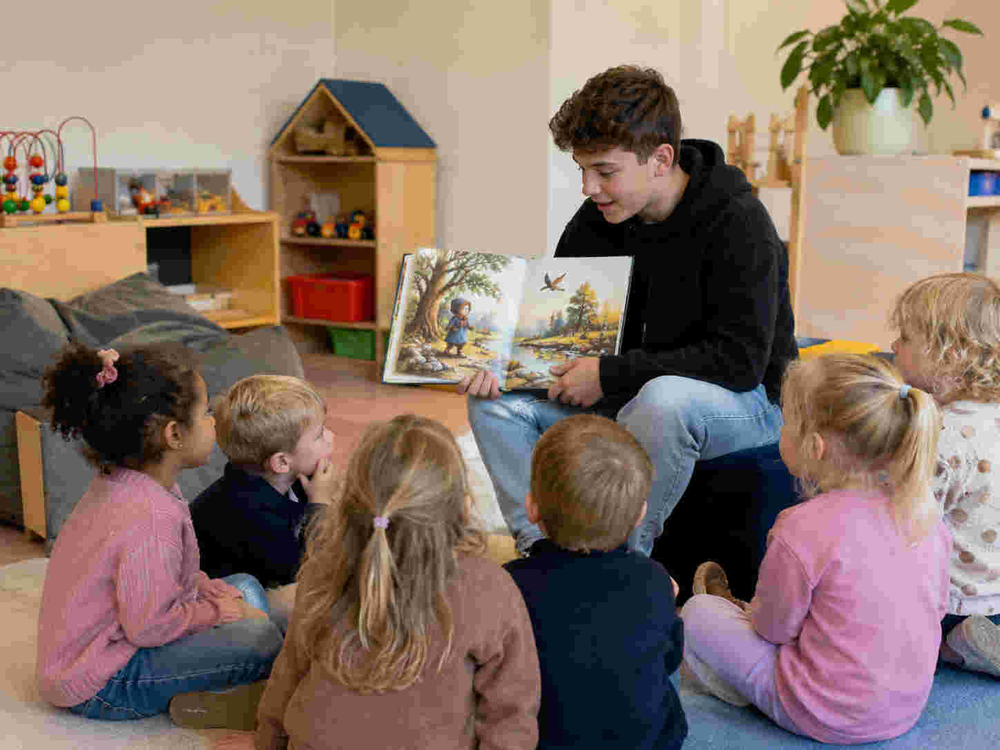 Leerling leest voor aan groep peuters