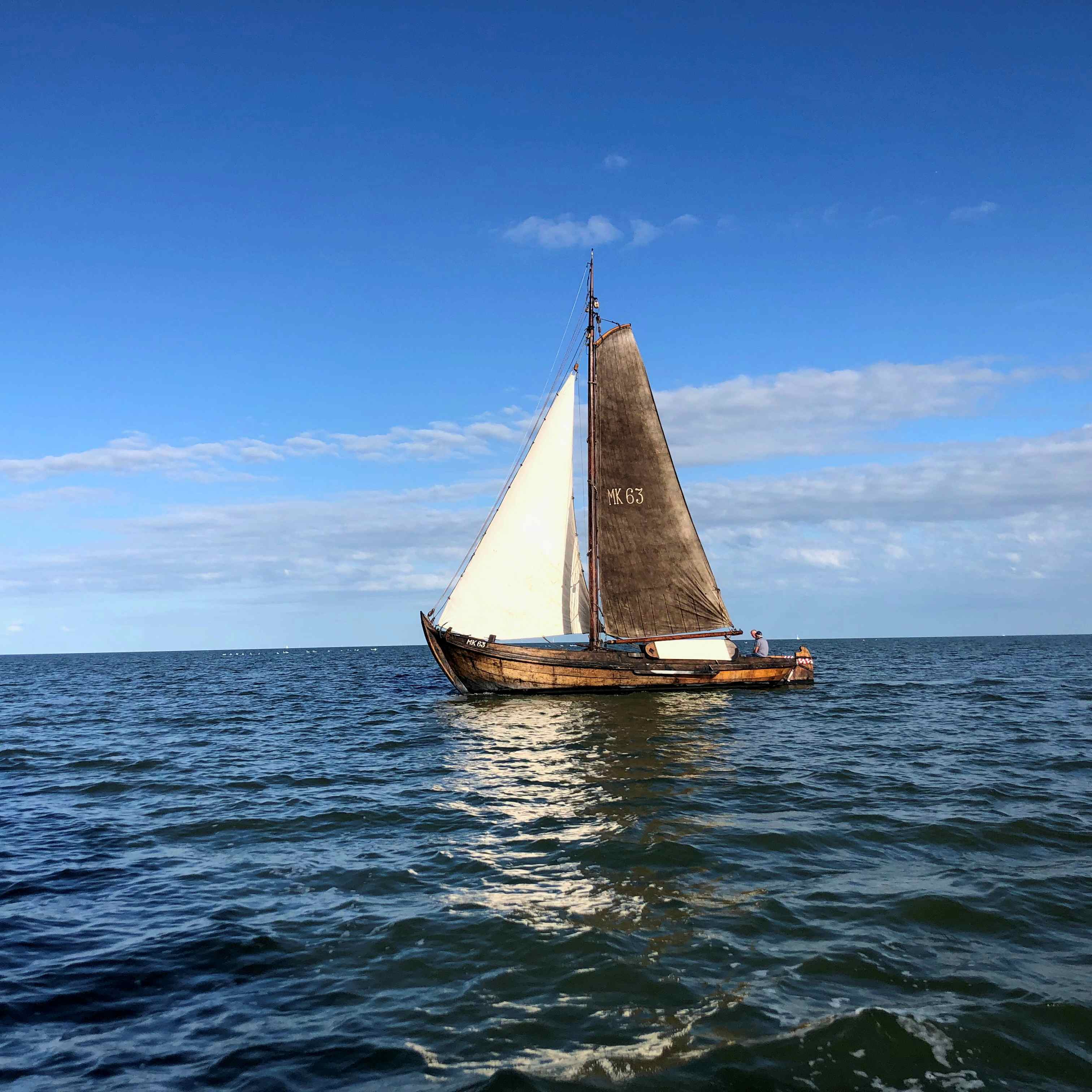 Schipper of maat op een historisch, zeilend vissersschip