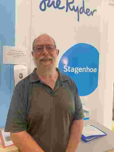 Photo of Jim wearing glasses with a grey beard, smiling at the camera, with the word Stagenhoe in the background