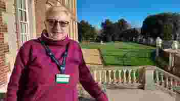Claire Edwards Volunteer for Wimpole outside the house on a sunny day with a view over the garden