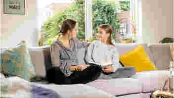 twee personen op de bank kijken samen in een boek