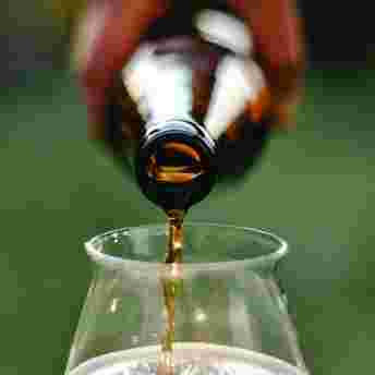 Bier schenken Bier uit een flesje in een glas schenken