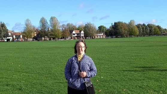 Young lady standing in a field looking at the camera. 