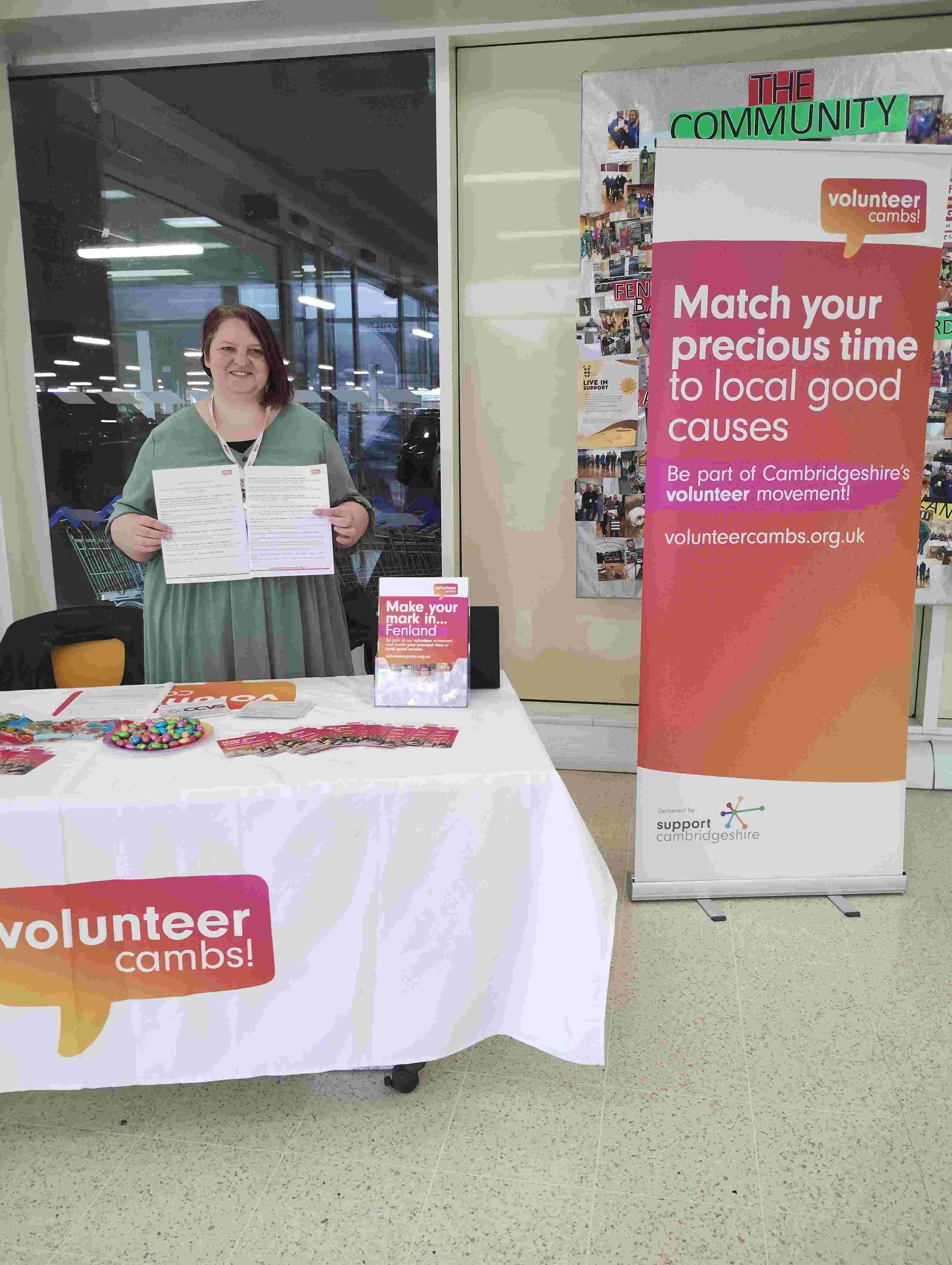 Rima standing at an event with sign
