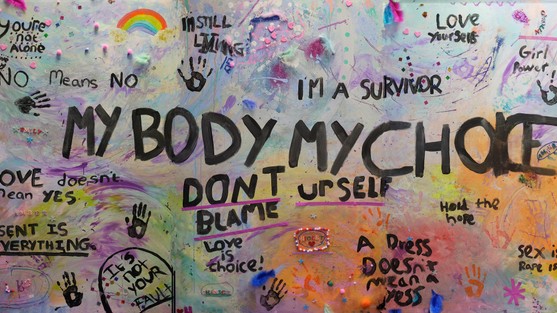 A colourful wall with graffiti all over it. the main text reads 'my body my choice'