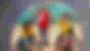 Man in red T shirt standing in between two children in sport wheelchairs who are playing badminton