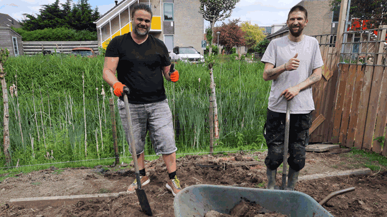 Vrijwilligers, naast een kruiwagen.