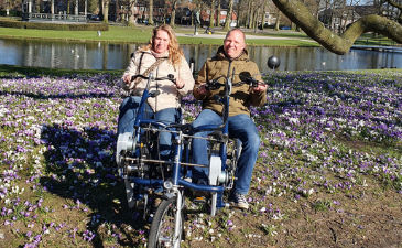 Fietsmaatjes Apeldoorn en Omstreken gaat van start. Vrijwilligers stappen met gasten op de duofiets voor een ritje. 