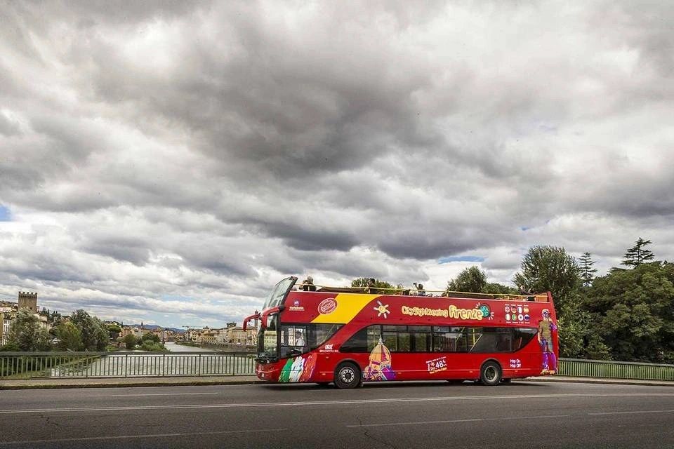  City Sightseeing Florence Hop-On Hop-Off Bus driving across a bridge in Florence, Italy