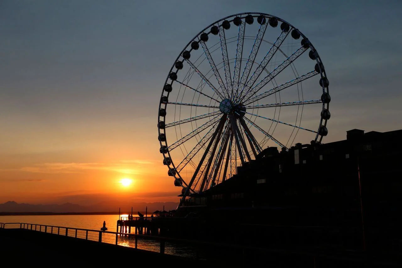 Seattle Great Wheel silhouetted against a vibrant sunset at Pier 57 along the Elliott Bay waterfront in Seattle, Washington
