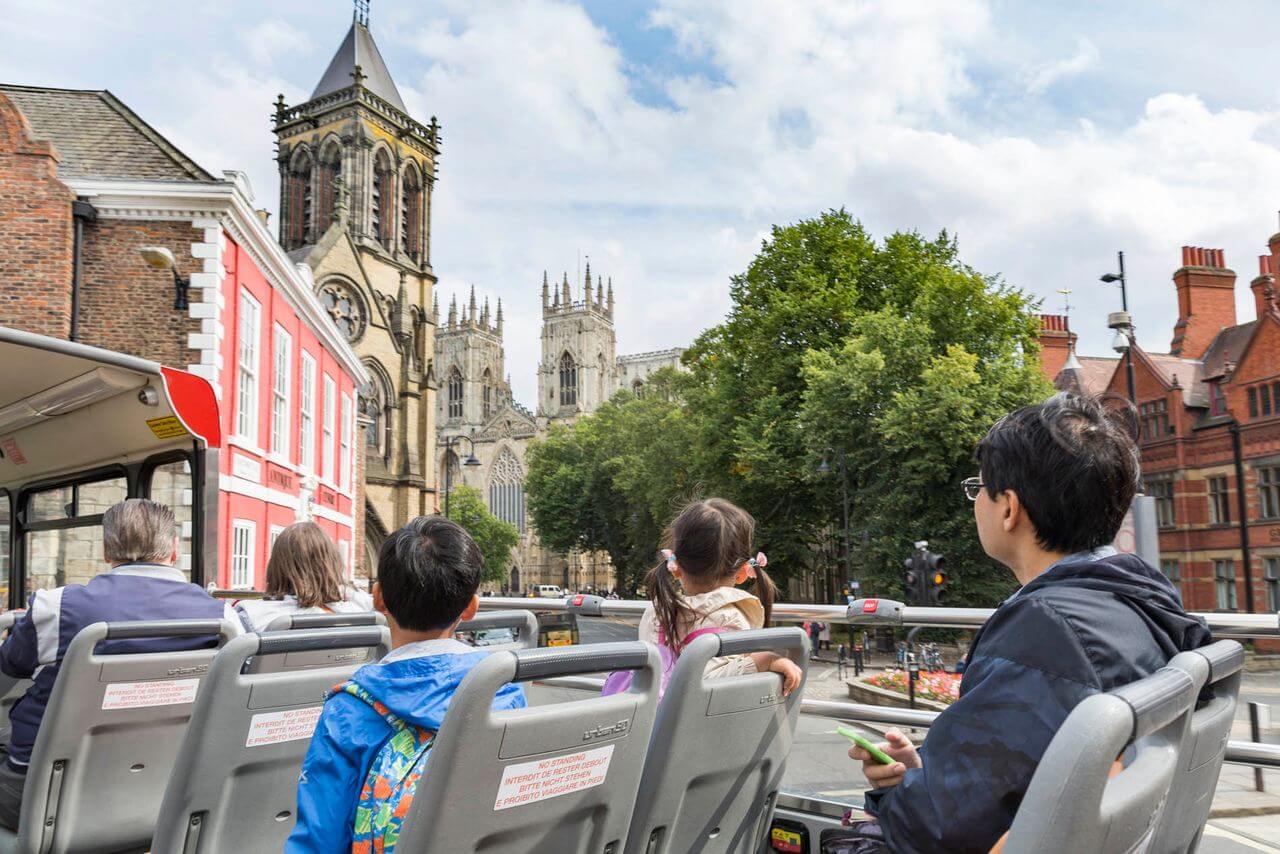 City Sightseeing tour bus with a clear view of the historic York Minster cathedral in York, England